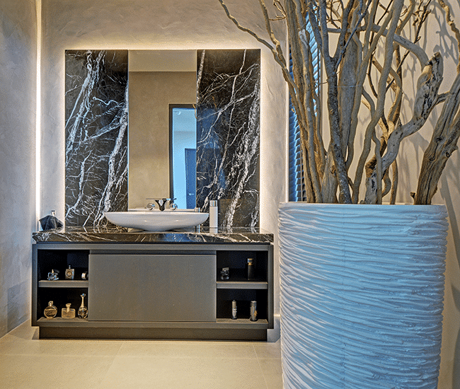 Badezimmer Unterschrank aus grauem Holz mit Marmor-Wandverkleidung